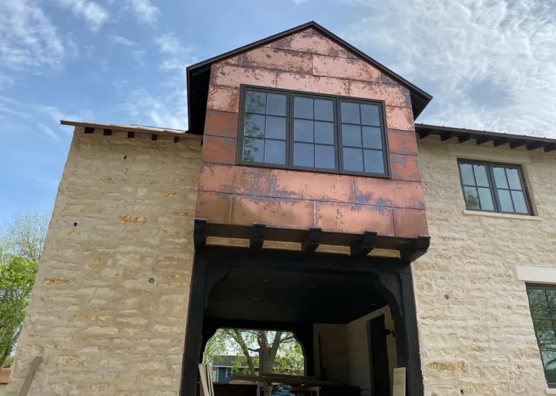 Copper metal panel facade on a stone building for Skylight Installation in White Oak
